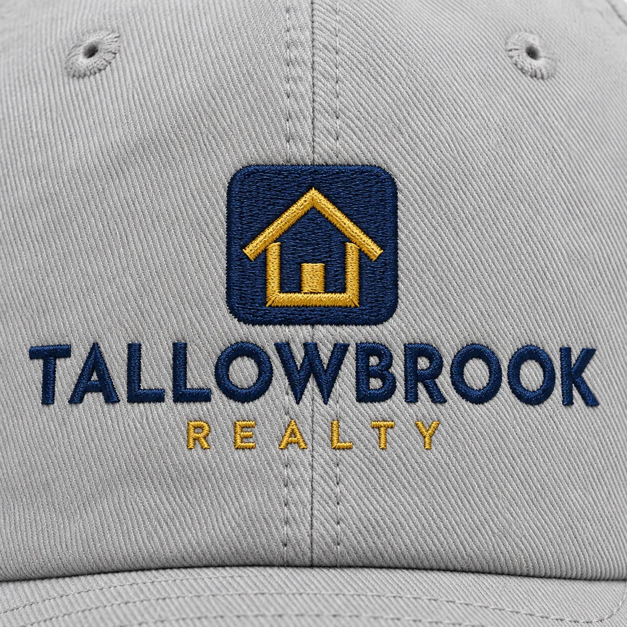 Custom Embroidered Dad Hats: Close up of raised embroidery on a light gray dad hat, sample artwork for a fictional brand
