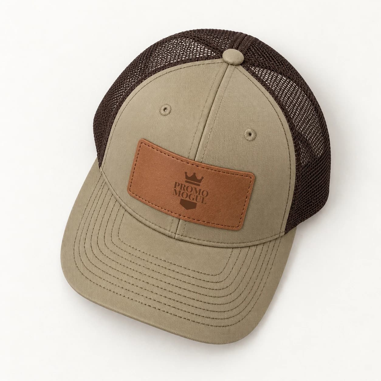 Custom Leather Patch Trucker Hats: Overhead view of a khaki trucker hat with coffee brown mesh, a tan rectangular stitched leather patch and dark brown PromoMogul sample badge