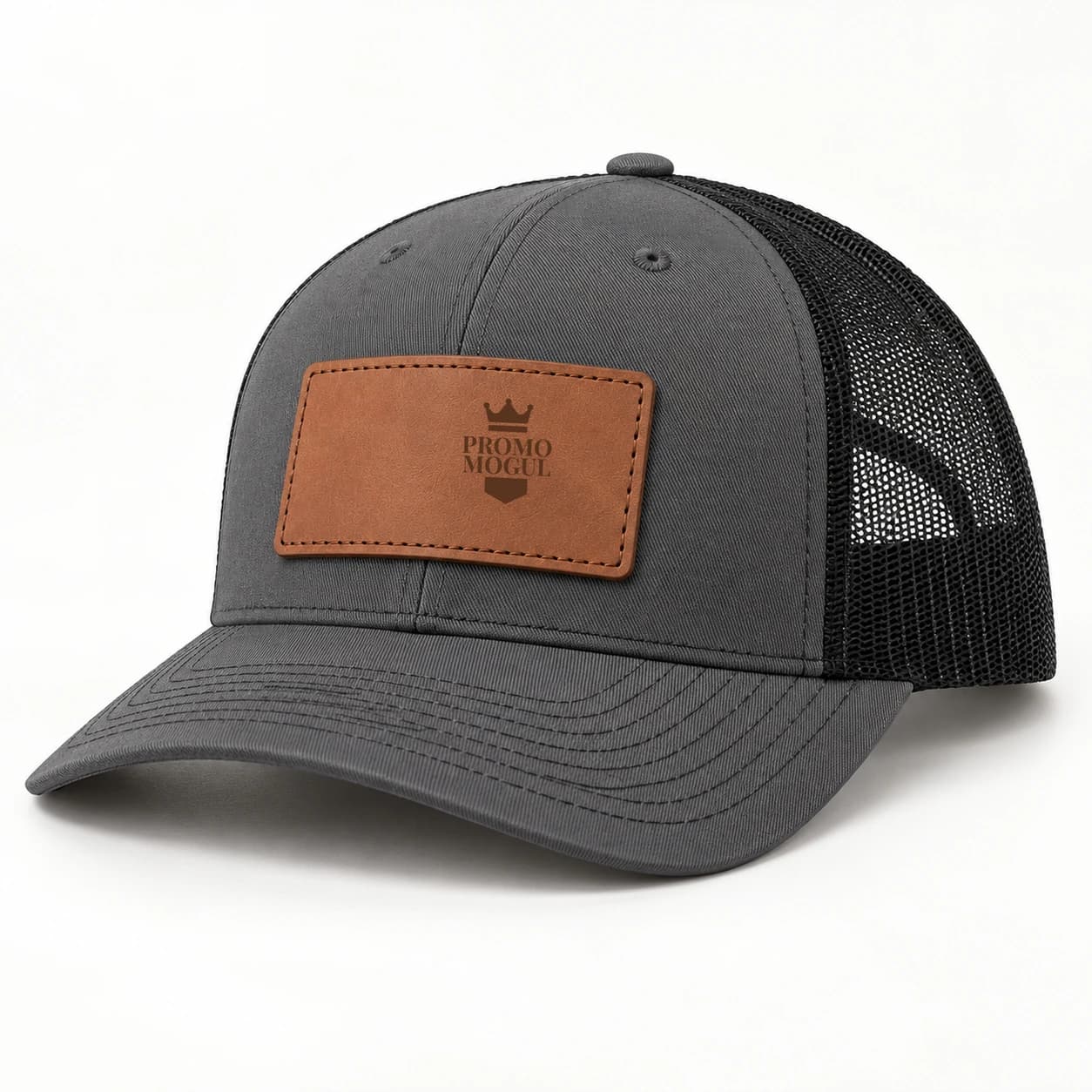 Charcoal trucker hat with a black mesh back, tan rectangular stitched leather patch and dark brown PromoMogul sample badge