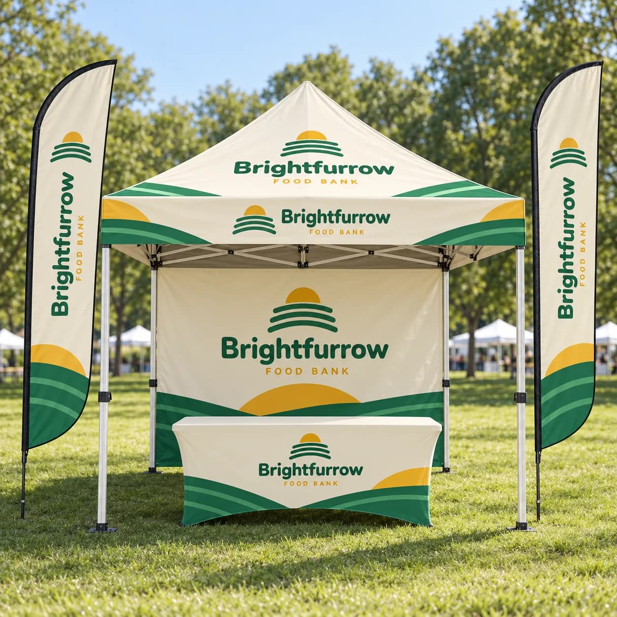 Pro Booth Kit, 10 x 10 Tent with Back Wall and 2 Flags: Pro Booth Kit on grass at a park event: a 10 x 10 ft canopy tent with a full back wall, two 9 ft feather flags on ground stakes and a 6 ft stretch table cover, printed with sample artwork for a fictional brand