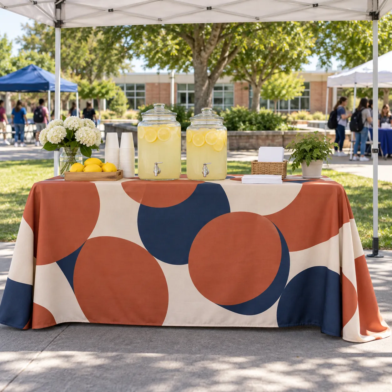 Premium Full-Color Table Covers & Throws: A printed table throw on a table under a tent at a school fair